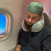 Thumbnail for Personne utilisant un coussin de voyage ergonomique gris perle en velours dans un avion. Accessoire confortable et compact, idéal pour soutenir la nuque pendant les déplacements.