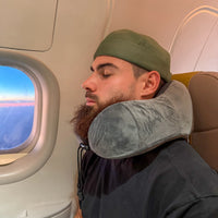 Thumbnail for Homme relaxant avec un coussin de voyage en velours gris anthracite, offrant un soutien ergonomique pour le cou lors d'un voyage en avion. Accessoire idéal pour un confort durable.