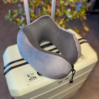 Thumbnail for Coussin de voyage en velours gris anthracite posé sur une valise. Confortable, ergonomique, et équipé de mousse à mémoire de forme pour un soutien optimal lors de vos déplacements.