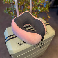 Thumbnail for Oreiller de voyage en velours rose posé sur une valise, parfait pour des trajets confortables grâce à sa mousse à mémoire de forme et son design ergonomique.